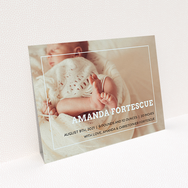 A birth announcement card called "Over Photo Frame". It is an A6 card in a landscape orientation. It is a photographic birth announcement card with room for 1 photo. "Over Photo Frame" is available as a flat card, with mainly light blue colouring.