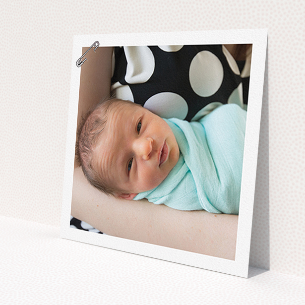 A birth announcement card design titled 'Put a pin in it'. It is a square (148mm x 148mm) card in a square orientation. It is a photographic birth announcement card with room for 1 photo. 'Put a pin in it' is available as a flat card, with mainly white colouring.