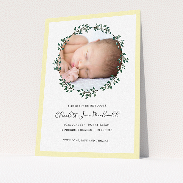 A birth announcement card named "Wreath Window". It is an A5 card in a portrait orientation. It is a photographic birth announcement card with room for 1 photo. "Wreath Window" is available as a flat card, with tones of green and yellow.