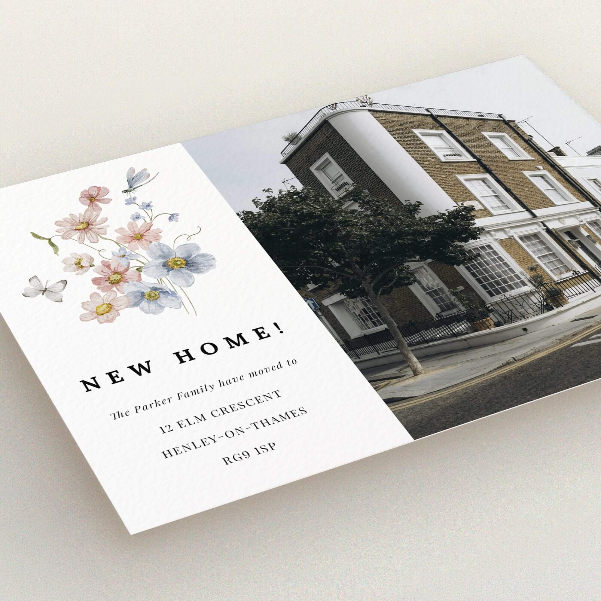 Floral design change of address card with one photo of a traditional house.