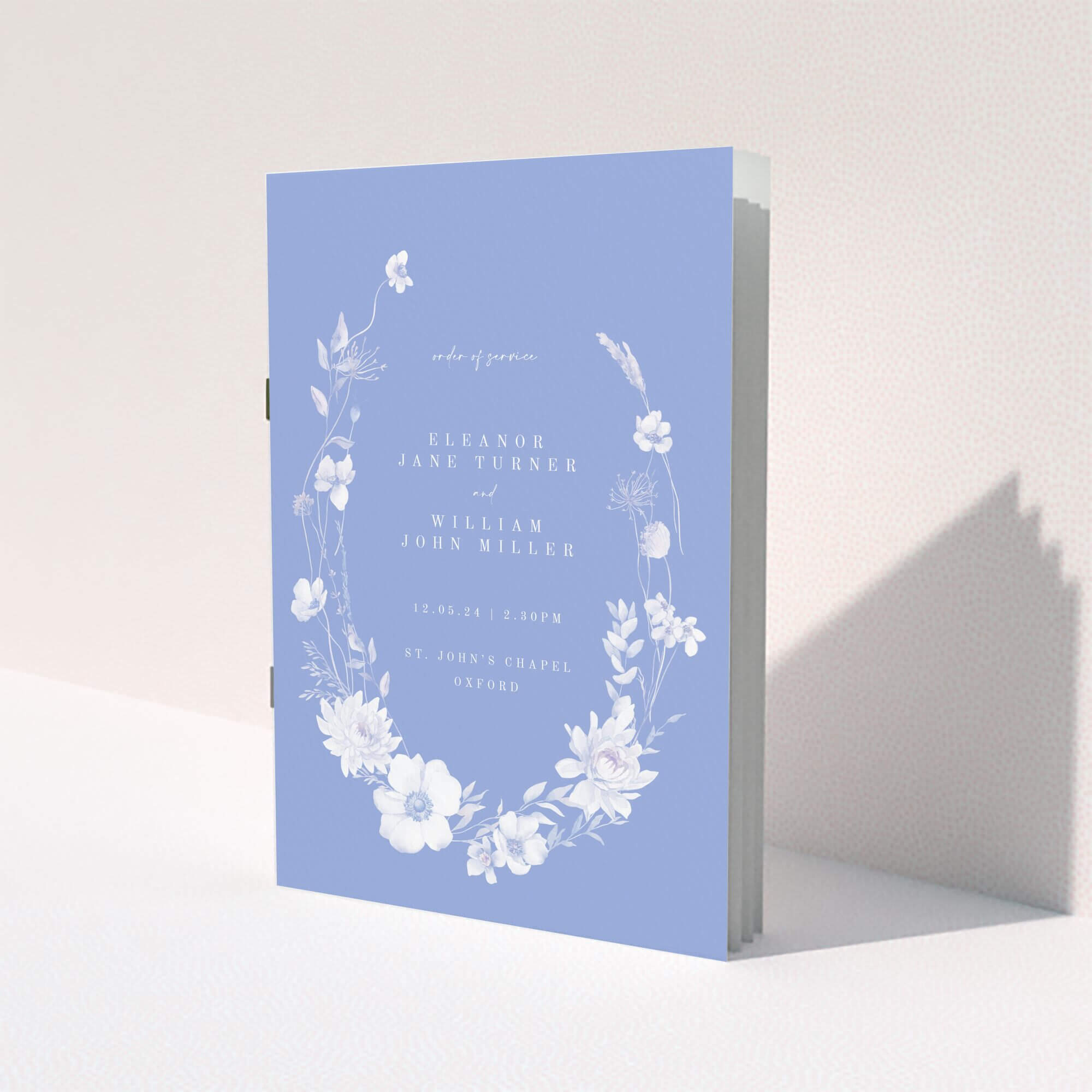 Elegant floral wedding order of service programme with two photos on a lavender background.