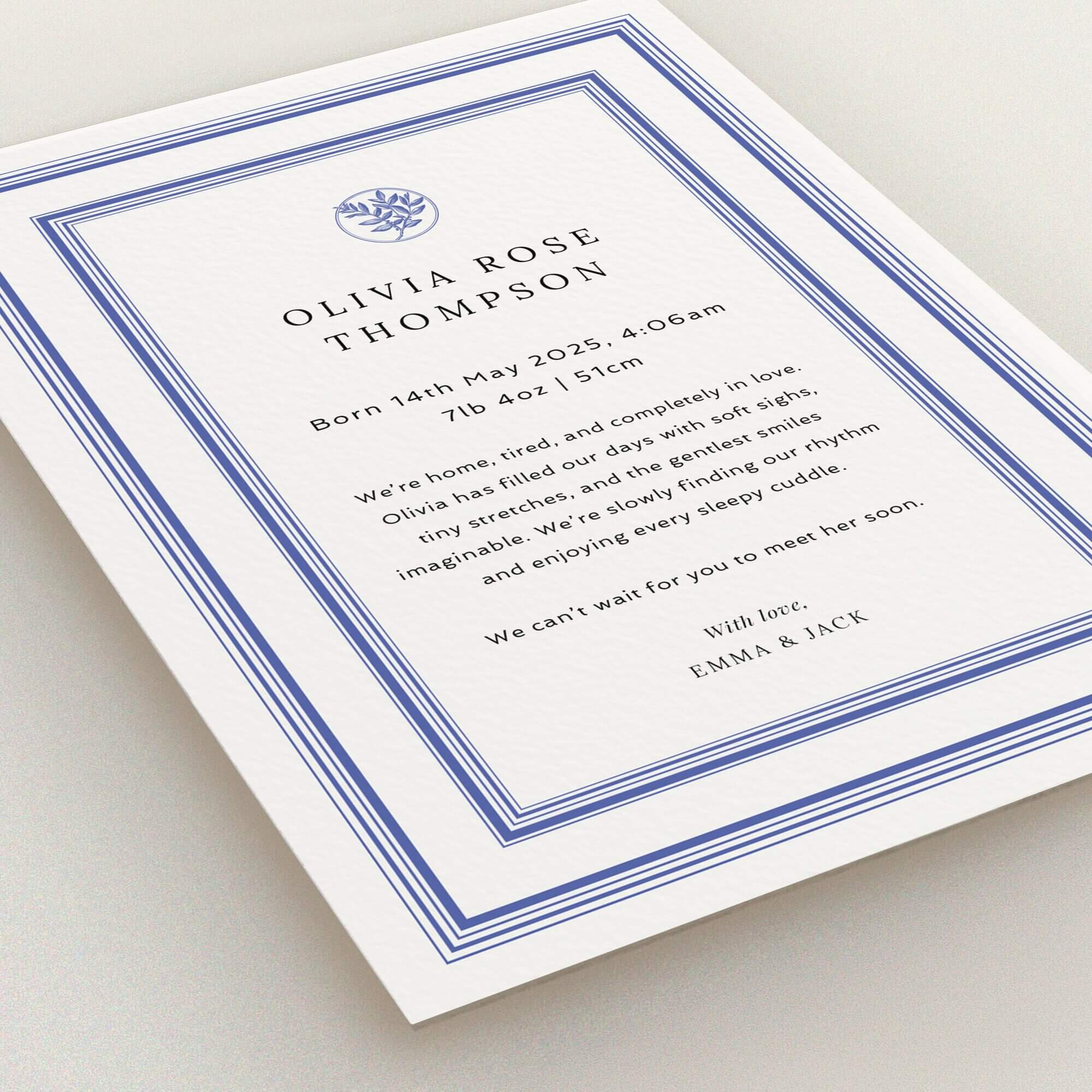 Elegant birth announcement card design with one photo and floral accent in blue borders.