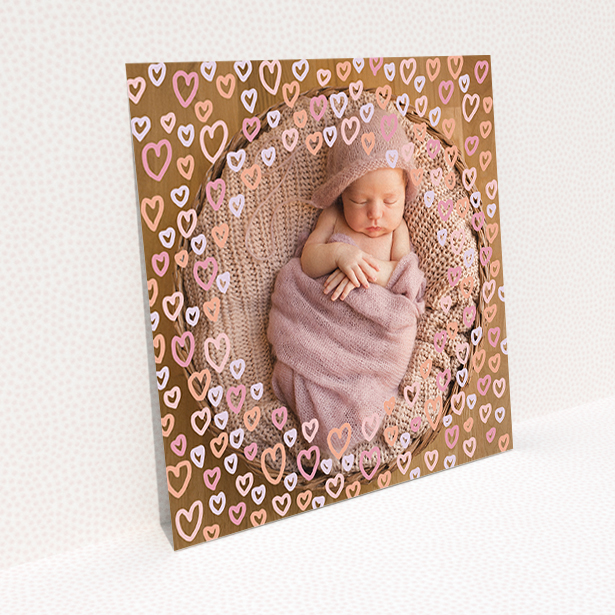 A christening invite design called "Pink Hearts". It is a square (148mm x 148mm) invite in a square orientation. It is a photographic christening invite with room for 1 photo. "Pink Hearts" is available as a flat invite, with mainly pink colouring.