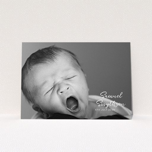 A christening invite named "Soho Script". It is an A6 invite in a landscape orientation. It is a photographic christening invite with room for 1 photo. "Soho Script" is available as a flat invite, with mainly white colouring.