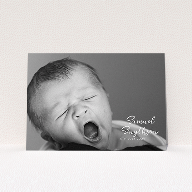 A christening invite named "Soho Script". It is an A6 invite in a landscape orientation. It is a photographic christening invite with room for 1 photo. "Soho Script" is available as a flat invite, with mainly white colouring.