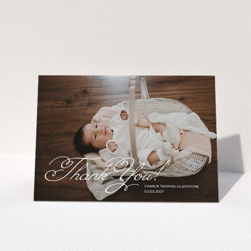 A christening thank you card called "Flourished Thank You". It is an A5 card in a landscape orientation. It is a photographic christening thank you card with room for 1 photo. "Flourished Thank You" is available as a folded card, with mainly white colouring.