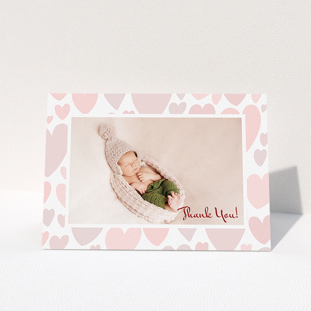 A christening thank you card template titled "Pastel Hearts". It is an A5 card in a landscape orientation. It is a photographic christening thank you card with room for 1 photo. "Pastel Hearts" is available as a folded card, with tones of pink and white.