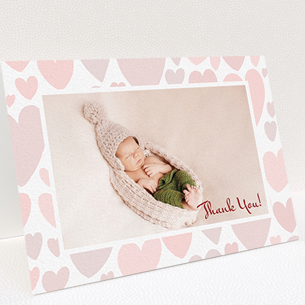 A christening thank you card called "Pastel Hearts". It is an A6 card in a landscape orientation. It is a photographic christening thank you card with room for 1 photo. "Pastel Hearts" is available as a folded card, with tones of pink and white.