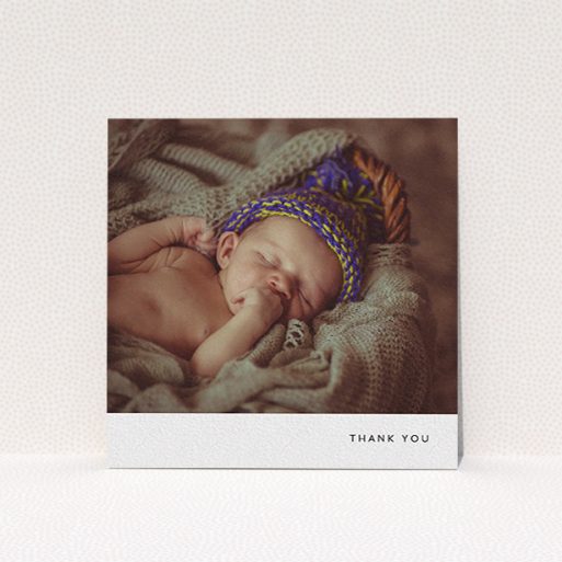 A christening thank you card design named "Thankful with Simplicity". It is a square (148mm x 148mm) card in a square orientation. It is a photographic christening thank you card with room for 1 photo. "Thankful with Simplicity" is available as a flat card, with mainly white colouring.