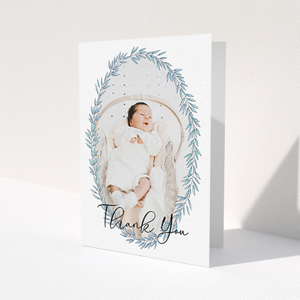 A christening thank you card design titled "Tussled Wreath". It is an A6 card in a portrait orientation. It is a photographic christening thank you card with room for 1 photo. "Tussled Wreath" is available as a folded card, with tones of blue and white.