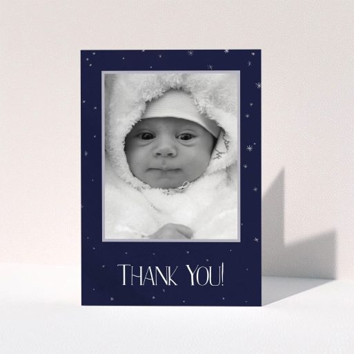 A christening thank you card template titled "Written in the Stars". It is an A6 card in a portrait orientation. It is a photographic christening thank you card with room for 1 photo. "Written in the Stars" is available as a folded card, with tones of dark blue, white and silver.