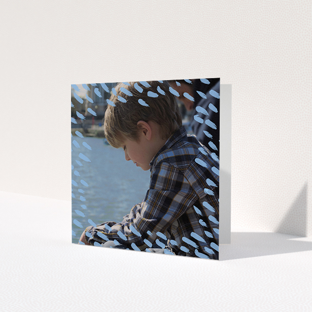 A communion thank you card called 'Blue Daubs'. It is a square (148mm x 148mm) card in a square orientation. It is a photographic communion thank you card with room for 1 photo. 'Blue Daubs' is available as a folded card, with mainly blue colouring.