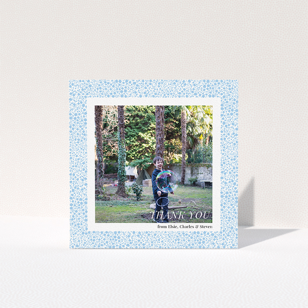 A communion thank you card design titled "Blue Floral Frame". It is a square (148mm x 148mm) card in a square orientation. It is a photographic communion thank you card with room for 1 photo. "Blue Floral Frame" is available as a folded card, with tones of blue and white.