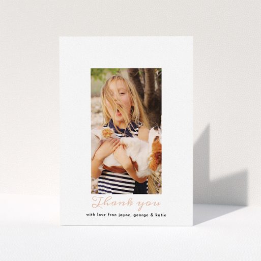 A communion thank you card called "Central Portrait". It is an A5 card in a portrait orientation. It is a photographic communion thank you card with room for 1 photo. "Central Portrait" is available as a folded card, with tones of white and pink.