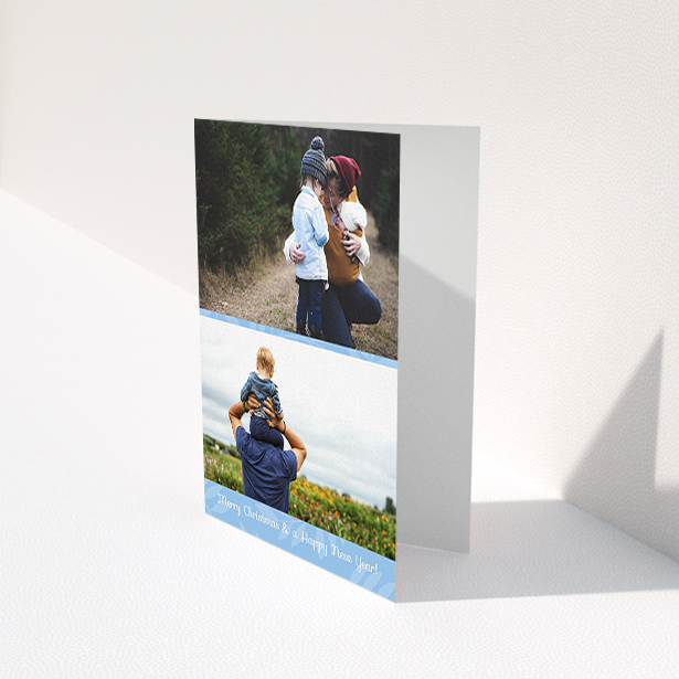 A custom christmas card design titled "Christmas Morning". It is an A6 card in a portrait orientation. It is a photographic custom christmas card with room for 2 photos. "Christmas Morning" is available as a folded card, with mainly blue colouring.