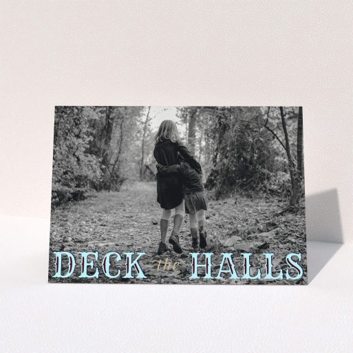 A custom christmas card named "Deck the Halls". It is an A5 card in a landscape orientation. It is a photographic custom christmas card with room for 1 photo. "Deck the Halls" is available as a folded card, with tones of blue and beige.