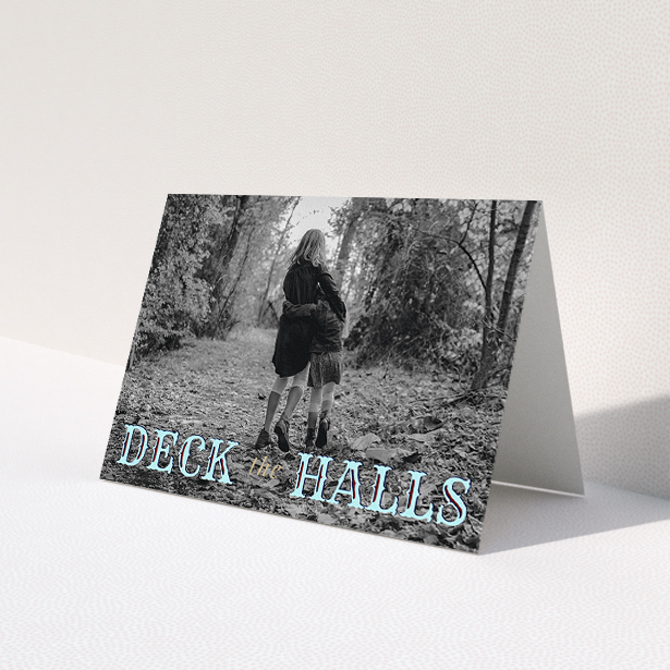 A custom christmas card named 'Deck the Halls'. It is an A5 card in a landscape orientation. It is a photographic custom christmas card with room for 1 photo. 'Deck the Halls' is available as a folded card, with tones of blue and beige.