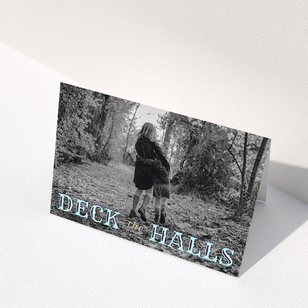 A custom christmas card named "Deck the Halls". It is an A5 card in a landscape orientation. It is a photographic custom christmas card with room for 1 photo. "Deck the Halls" is available as a folded card, with tones of blue and beige.