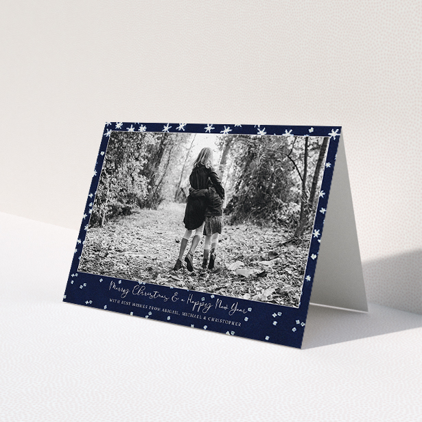 A custom christmas card design called 'Falling Snow at Night'. It is an A5 card in a landscape orientation. It is a photographic custom christmas card with room for 1 photo. 'Falling Snow at Night' is available as a folded card, with tones of blue and white.