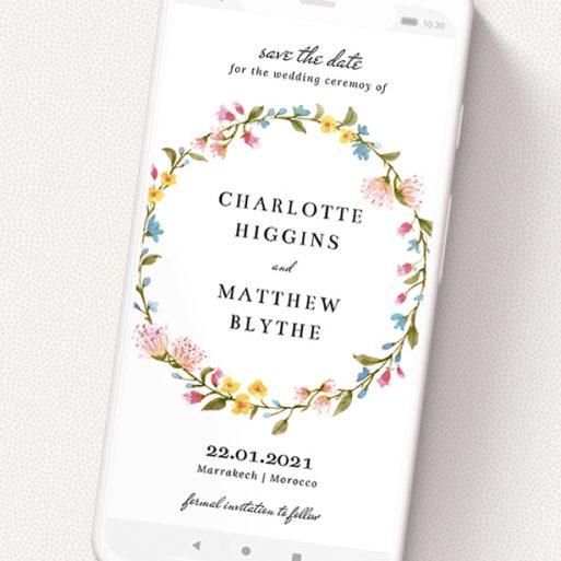 A digital save the date template titled 'Spring Wreath'. It is a smartphone screen sized save the date in a portrait orientation. 'Spring Wreath' is available as a flat save the date, with mainly pink colouring.
