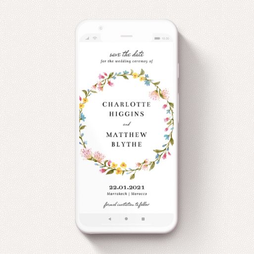 A digital save the date template titled "Spring Wreath". It is a smartphone screen sized save the date in a portrait orientation. "Spring Wreath" is available as a flat save the date, with mainly pink colouring.