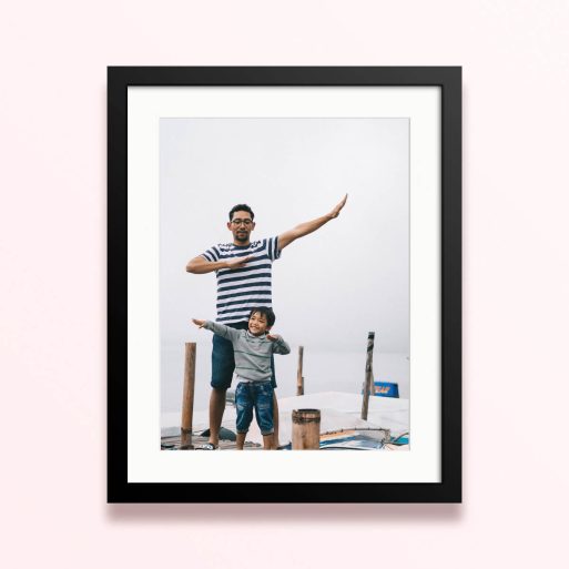 Framed and mounted photo print with 1 photo of a father and child sharing a joyful moment outdoors.