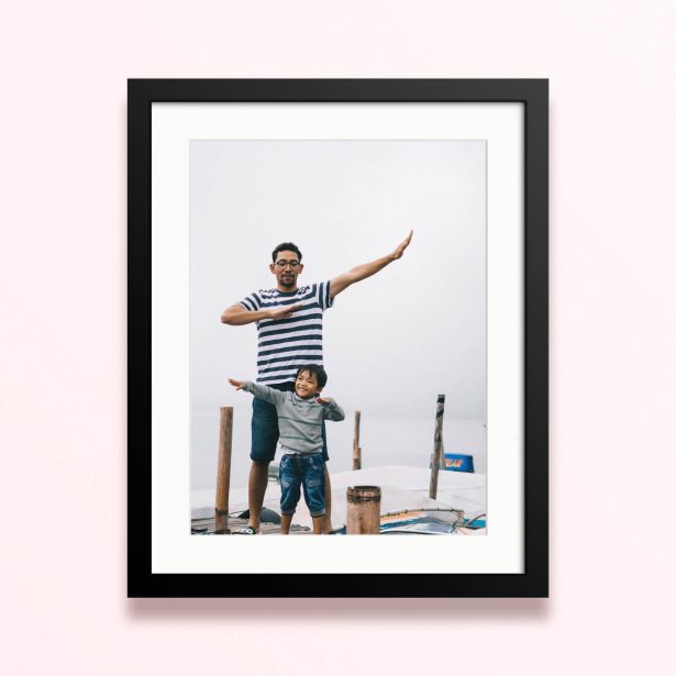 Framed and mounted photo print with 1 photo of a father and child sharing a joyful moment outdoors.