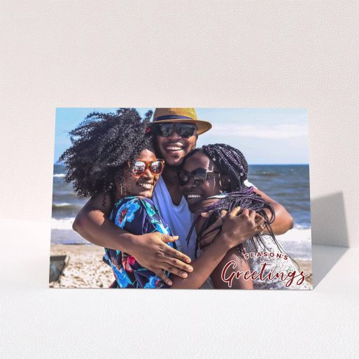 A family christmas card named "Christmas Stamp". It is an A5 card in a landscape orientation. It is a photographic family christmas card with room for 1 photo. "Christmas Stamp" is available as a folded card, with mainly red colouring.