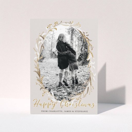 A family christmas card named "Christmas Wreath". It is an A6 card in a portrait orientation. It is a photographic family christmas card with room for 1 photo. "Christmas Wreath" is available as a folded card, with tones of cream, gold and white.