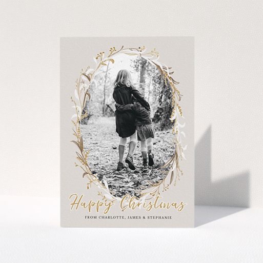 A family christmas card named "Christmas Wreath". It is an A6 card in a portrait orientation. It is a photographic family christmas card with room for 1 photo. "Christmas Wreath" is available as a folded card, with tones of cream, gold and white.
