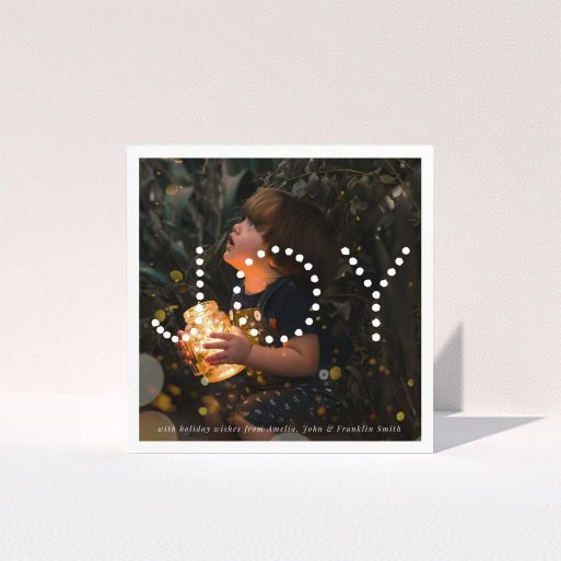 A family christmas card design titled "Joy". It is a square (148mm x 148mm) card in a square orientation. It is a photographic family christmas card with room for 1 photo. "Joy" is available as a folded card, with mainly white colouring.