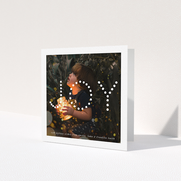 A family christmas card design titled "Joy". It is a square (148mm x 148mm) card in a square orientation. It is a photographic family christmas card with room for 1 photo. "Joy" is available as a folded card, with mainly white colouring.