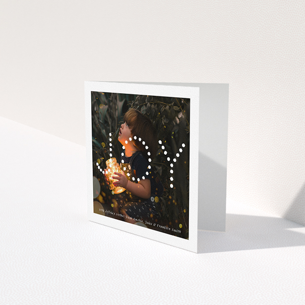 A family christmas card design titled "Joy". It is a square (148mm x 148mm) card in a square orientation. It is a photographic family christmas card with room for 1 photo. "Joy" is available as a folded card, with mainly white colouring.