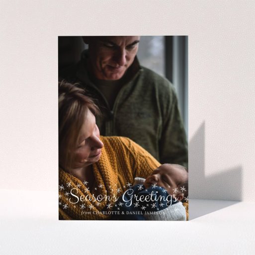 A family christmas card template titled "Sparkling Snow". It is an A5 card in a portrait orientation. It is a photographic family christmas card with room for 1 photo. "Sparkling Snow" is available as a folded card, with mainly white colouring.