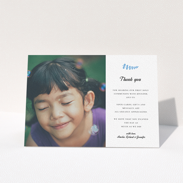A first holy communion thank you card design called "Blue Fern". It is an A6 card in a landscape orientation. It is a photographic first holy communion thank you card with room for 1 photo. "Blue Fern" is available as a folded card, with tones of white and blue.