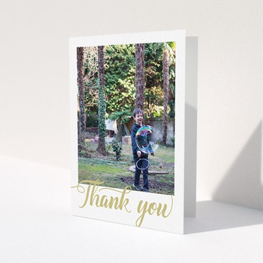 A first holy communion thank you card design called 'Golden Thank You'. It is an A6 card in a portrait orientation. It is a photographic first holy communion thank you card with room for 1 photo. 'Golden Thank You' is available as a folded card, with tones of cream and gold.