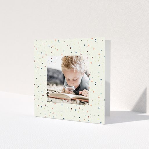 A first holy communion thank you card design titled 'Pastel Dots'. It is a square (148mm x 148mm) card in a square orientation. It is a photographic first holy communion thank you card with room for 1 photo. 'Pastel Dots' is available as a folded card, with mainly cream colouring.