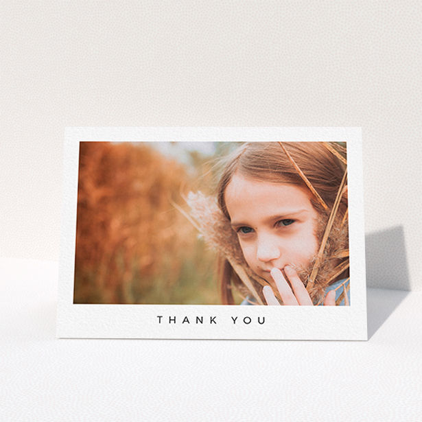 A first holy communion thank you card design called "Simple Thanks". It is an A6 card in a landscape orientation. It is a photographic first holy communion thank you card with room for 1 photo. "Simple Thanks" is available as a folded card, with mainly white colouring.