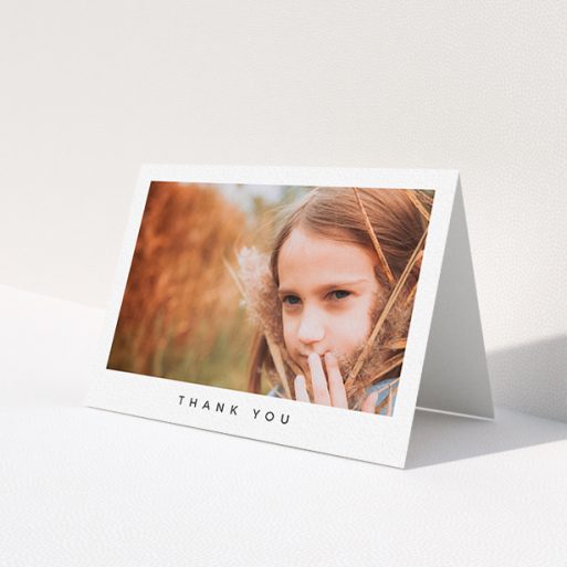 A first holy communion thank you card design called 'Simple Thanks'. It is an A6 card in a landscape orientation. It is a photographic first holy communion thank you card with room for 1 photo. 'Simple Thanks' is available as a folded card, with mainly white colouring.