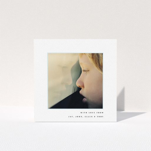 A first holy communion thank you card design titled "Thin Blue Frame". It is a square (148mm x 148mm) card in a square orientation. It is a photographic first holy communion thank you card with room for 1 photo. "Thin Blue Frame" is available as a folded card, with mainly white colouring.
