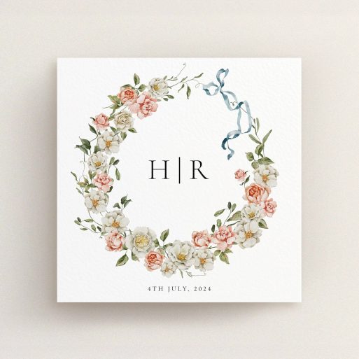 Floral wreath wedding invitation design with monogram and blue ribbon, no photos included.