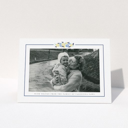 A funeral thank you card template titled "Remembered in flowers". It is an A5 card in a landscape orientation. It is a photographic funeral thank you card with room for 1 photo. "Remembered in flowers" is available as a folded card, with tones of white and blue.