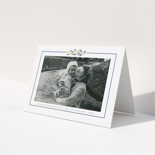A funeral thank you card called 'Remembered in flowers'. It is an A6 card in a landscape orientation. It is a photographic funeral thank you card with room for 1 photo. 'Remembered in flowers' is available as a folded card, with tones of white and blue.