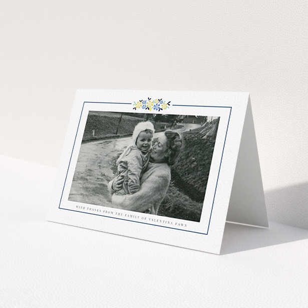 A funeral thank you card called "Remembered in flowers". It is an A6 card in a landscape orientation. It is a photographic funeral thank you card with room for 1 photo. "Remembered in flowers" is available as a folded card, with tones of white and blue.