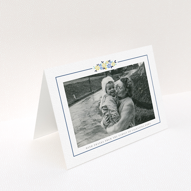 A funeral thank you card called "Remembered in flowers". It is an A6 card in a landscape orientation. It is a photographic funeral thank you card with room for 1 photo. "Remembered in flowers" is available as a folded card, with tones of white and blue.