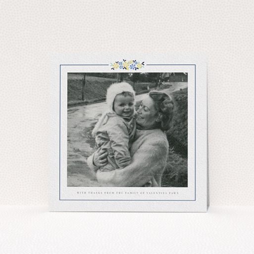 A funeral thank you card template titled "Remembered in flowers". It is a square (148mm x 148mm) card in a square orientation. It is a photographic funeral thank you card with room for 1 photo. "Remembered in flowers" is available as a flat card, with tones of white and blue.
