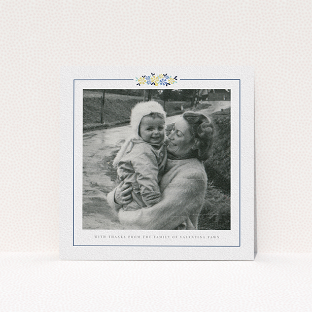 A funeral thank you card template titled "Remembered in flowers". It is a square (148mm x 148mm) card in a square orientation. It is a photographic funeral thank you card with room for 1 photo. "Remembered in flowers" is available as a flat card, with tones of white and blue.