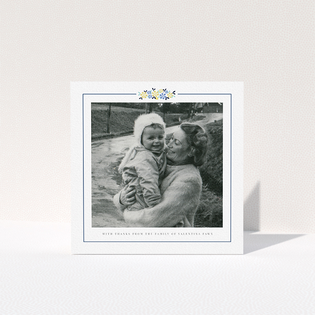 A funeral thank you card design titled "Remembered in flowers". It is a square (148mm x 148mm) card in a square orientation. It is a photographic funeral thank you card with room for 1 photo. "Remembered in flowers" is available as a folded card, with tones of white and blue.