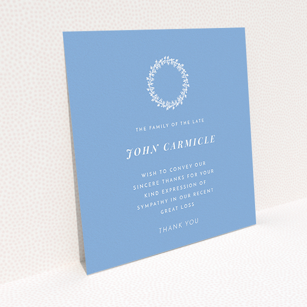 A funeral thank you card design named "White Wreath in Blue". It is a square (148mm x 148mm) card in a square orientation. "White Wreath in Blue" is available as a flat card, with tones of blue and white.