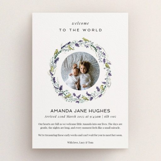 Floral wreath birth announcement card with two photos of siblings.